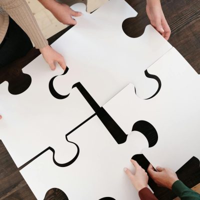 Photo by Diva Plavalaguna Group collaborating on assembling large puzzle pieces symbolizing teamwork and unity.
